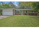 Charming single-story home with well-manicured lawn, green shutters and a front-facing garage at 622 Sheffield Rd, Norcross, GA 30071