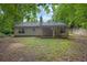 Backyard featuring siding, covered patio, green grass, and lush trees at 10073 Dorothy Ct, Jonesboro, GA 30236