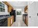 Galley kitchen with black appliances and oak cabinets, offering a functional design at 10073 Dorothy Ct, Jonesboro, GA 30236