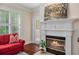 Close-up of the fireplace, featuring a white mantle, a painting, and a door leading to the outside at 2400 Cumberland Se Pkwy # 613, Atlanta, GA 30339