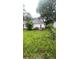 Overgrown backyard featuring a deck, grassy area, and surrounding foliage at 4 Ivy St, Porterdale, GA 30014