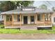 Charming single-story home with a welcoming front porch and mature trees in the background at 4 Ivy St, Porterdale, GA 30014