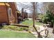 Beautiful backyard with a wooden boardwalk leading to the manicured lawn and brick home at 5352 Lacosta Ln, Alpharetta, GA 30022