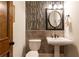 Charming powder room featuring decorative mosaic tile and round mirror at 5352 Lacosta Ln, Alpharetta, GA 30022