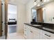 Bright bathroom with white vanity, black countertop, and view to the bedroom at 5352 Lacosta Ln, Alpharetta, GA 30022