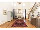 Bright living room with hardwood floors, fireplace, staircase, and tall windows at 5352 Lacosta Ln, Alpharetta, GA 30022