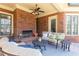 Inviting covered patio with brick fireplace, comfortable seating, and stylish decor at 5352 Lacosta Ln, Alpharetta, GA 30022