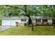 Charming ranch-style home featuring a stone accent wall, a well-manicured lawn, and a convenient two-car garage at 5517 Green Wing Ct, Lithonia, GA 30058