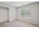Bedroom featuring a window letting in natural light, neutral carpeting, and a closet at 835 Navajo Trl, Covington, GA 30016