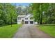 Traditional home featuring an attached two-car garage, mature trees, and long driveway at 835 Navajo Trl, Covington, GA 30016