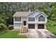 Traditional split-level home with an attached two-car garage, black shutters, and mature trees at 835 Navajo Trl, Covington, GA 30016