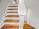Staircase featuring wooden treads and white risers, with natural light at 835 Navajo Trl, Covington, GA 30016