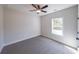 Bright bedroom featuring neutral walls, plush carpeting, a ceiling fan, and a window offering natural light at 96 Lexie Ct, Rockmart, GA 30153