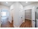 Bright hallway with wood floors and multiple doors leading to various rooms, including a laundry area at 96 Lexie Ct, Rockmart, GA 30153