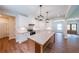 Open kitchen featuring white cabinets, stainless steel appliances, a large island, and wood-look flooring at 96 Lexie Ct, Rockmart, GA 30153