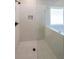 Modern tiled shower with glass enclosure and hexagon-tiled floor, offering a sleek and spacious design at 96 Lexie Ct, Rockmart, GA 30153
