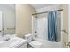 Bright bathroom featuring a shower with blue curtain, toilet, sink and vanity at 1039 Megan Ct, Sugar Hill, GA 30518