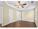 Cozy bedroom featuring a ceiling fan, wood-look flooring, and access to an attached bathroom at 1039 Megan Ct, Sugar Hill, GA 30518