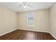 Cozy bedroom with wood-look floors, ceiling fan, and a window providing natural light at 1039 Megan Ct, Sugar Hill, GA 30518