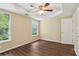 Spacious bedroom with wood-look flooring, a ceiling fan, and natural light from two windows at 1039 Megan Ct, Sugar Hill, GA 30518