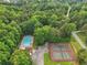 Aerial view of the community pool and tennis courts surrounded by beautiful trees at 1039 Megan Ct, Sugar Hill, GA 30518