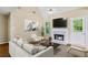 Bright living room with fireplace, high ceiling with fan, and a view to the backyard through the glass paneled door at 1039 Megan Ct, Sugar Hill, GA 30518