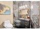Elegant bathroom featuring marble walls, a modern vanity with gold hardware, and a decorative mirror and wall sconces at 4670 Hamden Forest Sw Dr, Atlanta, GA 30331