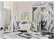Luxurious bathroom featuring a soaking tub, glass shower, and elegant marble accents and a decorative stain glass window at 4670 Hamden Forest Sw Dr, Atlanta, GA 30331