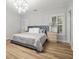 Bedroom with a large bed, wood floors, windows with shutters, and a decorative light fixture at 4670 Hamden Forest Sw Dr, Atlanta, GA 30331