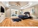 Expansive primary bedroom featuring hardwood floors, a tray ceiling, and a cozy sitting area by the windows at 4670 Hamden Forest Sw Dr, Atlanta, GA 30331