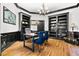 Spacious office with hardwood floors, built-in bookshelves, and a chandelier for soft, ambient lighting at 4670 Hamden Forest Sw Dr, Atlanta, GA 30331