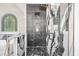 Sleek walk-in shower boasting black marble accents, dual shower heads, and a glass enclosure with gold fixtures at 4670 Hamden Forest Sw Dr, Atlanta, GA 30331