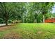 Large, lush backyard with mature trees and a wooden playset perfect for outdoor fun at 5610 N Allen Rd, Mableton, GA 30126