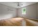 Sunlit bedroom features hardwood floors, a ceiling fan, and a large window at 5610 N Allen Rd, Mableton, GA 30126