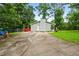 Charming single-story home featuring a spacious driveway, lush greenery, and a cozy red deck at 5610 N Allen Rd, Mableton, GA 30126