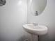 Elegant half bath with a pedestal sink, round mirror, and neutral decor at 3155 Tarian Way, Decatur, GA 30034
