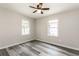 Bright bedroom with wood floors, ceiling fan and plenty of natural light from large windows at 8316 Grady St, Douglasville, GA 30134