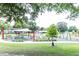 Community playground with swings, benches, and shade structure surrounded by green grass and trees at 8316 Grady St, Douglasville, GA 30134