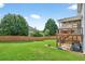 Large backyard with a wooden privacy fence, and a deck with stairs leading to the ground at 910 Pebble Creek Trl, Suwanee, GA 30024