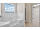 Bathroom featuring a luxurious soaking tub with a window and a walk-in shower at 910 Pebble Creek Trl, Suwanee, GA 30024