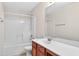 Bright bathroom featuring a shower-tub combo, wood vanity, and large mirror at 910 Pebble Creek Trl, Suwanee, GA 30024