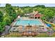 Community pool with a splash pad, lounge chairs, and a covered seating area at 910 Pebble Creek Trl, Suwanee, GA 30024