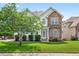 Charming two-story home featuring a combination of stone and siding with a well-manicured front lawn and mature tree at 910 Pebble Creek Trl, Suwanee, GA 30024