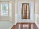 Bright foyer with hardwood floors, decorative molding, and a window-lined entry door at 910 Pebble Creek Trl, Suwanee, GA 30024