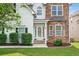 Inviting front entrance showcasing a decorative glass door, manicured bushes and stone exterior at 910 Pebble Creek Trl, Suwanee, GA 30024