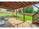 Covered patio with stone pavers, wood support beams and stairs leading to the upper deck at 910 Pebble Creek Trl, Suwanee, GA 30024