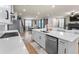 Open-concept kitchen with white cabinets, a central island, and views of the living area at 2456 Hidden Creek Rd, Kennesaw, GA 30152