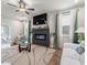 Cozy living room boasting a modern fireplace, ceiling fan, and natural light from large windows at 2456 Hidden Creek Rd, Kennesaw, GA 30152