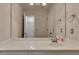 Bright bathroom featuring a vanity with white countertop, modern fixtures, and open closet space at 3028 Towneside Ln, Woodstock, GA 30189