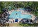 Wide aerial view of the community pool, picnic tables, tennis courts, baby pool and surrounding trees at 3028 Towneside Ln, Woodstock, GA 30189